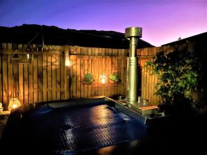 a backyard with a wooden fence with a fountain at Naurolukki #1 in Cape Town
