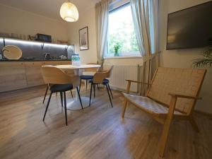 a living room with a table and chairs and a television at Willa Liliowa in Dębki