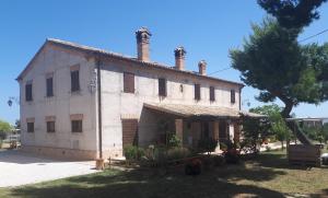 an old building with two chimneys on top of it at B&B I Pini Di Storaco in Filottrano