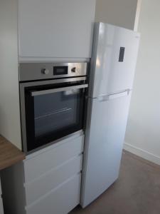 a kitchen with a refrigerator and a microwave at Superbe appartement proche des plages avec parking gratuit in Ramatuelle