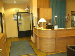 a hospital room with a reception desk with a clock at Hotel Alga in Ustka