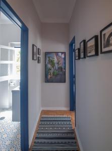 un pasillo con una puerta azul con una alfombra en Casa da Travessa - Obidos, en Óbidos