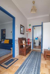 a living room with a blue door and a bed at Casa da Travessa - Óbidos in Óbidos