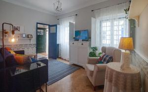 ein Wohnzimmer mit Sofa und Tisch in der Unterkunft Casa da Travessa - Óbidos in Óbidos