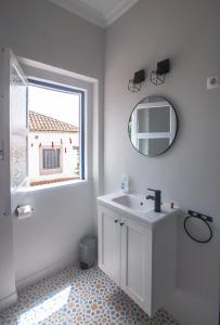 a bathroom with a sink and a mirror and a window at Casa da Travessa - Óbidos in Óbidos +22 photos