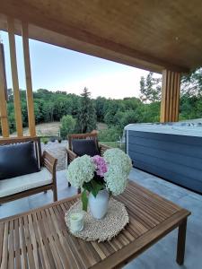 einen Tisch mit einer Blumenvase auf einer Terrasse in der Unterkunft Villa Magnolia in Sveti Martin na Muri