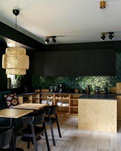 a kitchen with black cabinets and a table and chairs at DOM GÓRY LAS - zapraszamy gości dorosłych in Karpacz