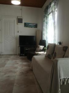 a living room with a couch and a television at City Hall House in Volos