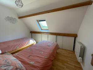 a attic room with two beds and a window at Gîte à la campagne mais proche de tout in Moringhem