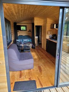 una pequeña casa con vistas a la sala de estar y a la cocina en Roulotte Escapade nature à Morainville - Normandie, en Morainville-près-Lieurey