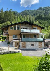 a large house with a balcony and a yard at Ferienwohnung Wildkogelblick in Bramberg am Wildkogel