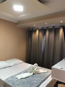 um quarto com dois cisnes deitados numa cama em Lá Casa do Manguinha em Guarulhos