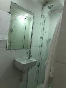 a bathroom with a sink and a shower with a mirror at Lá Casa do Manguinha in Guarulhos +22 photos