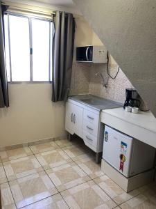 a small kitchen with a sink and a stove at Lá Casa do Manguinha in Guarulhos