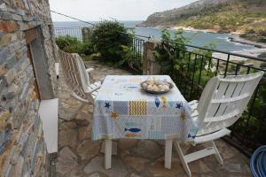 a table and chairs on a balcony with a view of the ocean at Blue Horizon Dream in Thymonia Beach