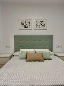 a bedroom with a large bed with a green headboard at MARINA AZUL GOLF in Ayamonte