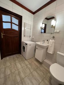 a bathroom with a toilet sink and a washing machine at Cozy apartment close to Gdansk & Airport in Gdańsk