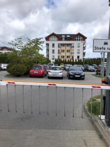 a parking lot with cars parked in front of a building at Cozy apartment close to Gdansk & Airport in Gdańsk