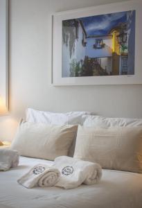 a bed with white sheets and towels on it at Casa da Travessa - Obidos in Óbidos