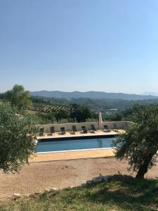 une piscine avec des chaises et des montagnes en arrière-plan dans l'établissement Agriturismo Sant'Angelo holiday farm, à Gualdo Cattaneo