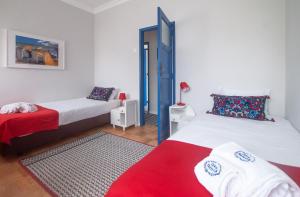 1 dormitorio con 2 camas y manta roja en Casa da Travessa - Obidos, en Óbidos