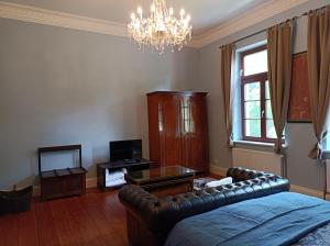 ein Wohnzimmer mit einem Sofa und einem Kronleuchter in der Unterkunft Herrenhaus Harmshagen in Testorf-Steinfort
