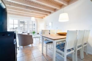a kitchen and dining room with a table and chairs at Iris Strandhus in Sierksdorf