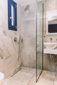 a bathroom with a shower and a sink at BLUE STONE Luxury Suites in Limenaria
