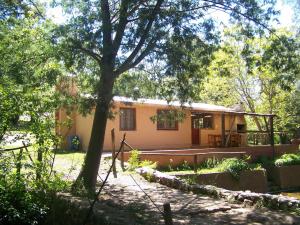 a house with a tree in front of it at Espejo Escondido in Tanti