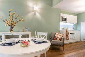 a kitchen with a white table and a dining room at Isola Bella Apartments Via Stretta in Stresa +5 photos