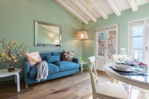a living room with a blue couch and a table at Isola Bella Apartments Via Stretta in Stresa