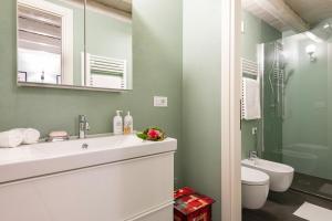 a bathroom with a sink and a toilet and a mirror at Isola Bella Apartments Via Stretta in Stresa