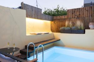 una piscina en un patio trasero con una mesa y una valla en arismari cretan holiday home, en Angouselianá
