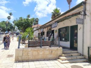 um edifício com um banco numa rua da cidade em my holiday apartment em Zikhron Ya‘aqov