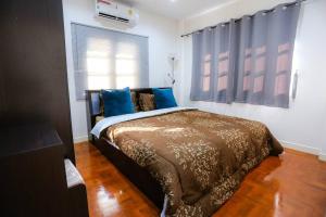 - une chambre avec un lit doté d'oreillers bleus et d'une fenêtre dans l'établissement Cozy hug home, à Ban Phak Wan Noi