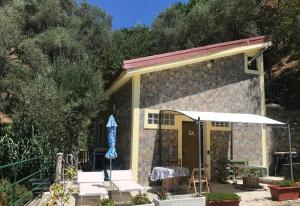 um pequeno edifício com uma mesa e um guarda-chuva em La Casetta di Sofia 2 em Moneglia