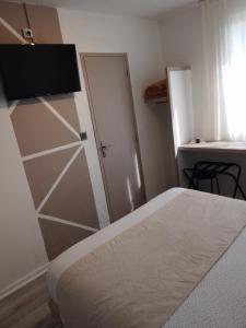 1 dormitorio con 1 cama y armario con puerta en Logis Drom'sud Hotel, en Donzère