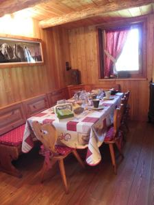 comedor con mesa y sillas en una cabaña en RASCARD D'ANTAN en Chamois