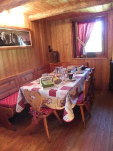 a dining room with a table and chairs in a cabin at RASCARD D'ANTAN in Chamois
