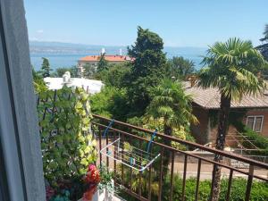 a balcony with a view of a house and the ocean at Guesthouse Villa Stanger in Lovran