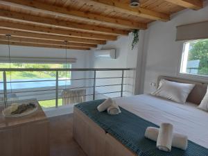 a bedroom with a large bed and a large window at KTIMA MORAITI - Seaside Houses in Katerini