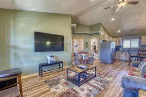 a living room with a tv and a couch and a table at --30 mins to Zion--Two Cabins w/ Game Room--Bryce/Lake Powell/Grand Canyon in Kanab +9 photos