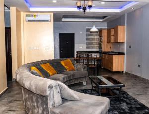 ein Wohnzimmer mit einem Sofa und einem Tisch in der Unterkunft COLINDALE COURT in Tema