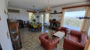 a living room with couches and a dining room at GEORGE'S VILLA in Galatas