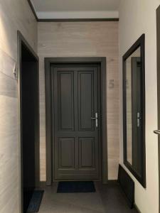 - un couloir avec une porte en bois et un miroir dans l'établissement Toronyi Vendégház, à Torony