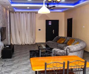 a living room with a couch and a table at COLINDALE COURT in Tema
