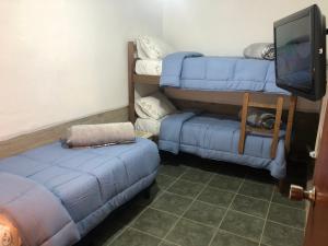 ein Wohnzimmer mit 2 blauen Sofas und einem Flachbild-TV in der Unterkunft LA POSADA in Aiguá
