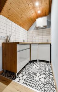 a kitchen with a black and white tile floor at Dom Wczasowy Radość in Rewal