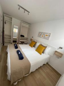sypialnia z dwoma łóżkami z żółtymi i niebieskimi poduszkami w obiekcie B-Rent Digital apartment Zen wifi free w Corralejo
