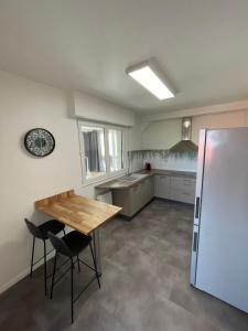 a kitchen with a wooden table and a refrigerator at A L'orée des vignes, superbe logement de 80 m2 in Wangen
